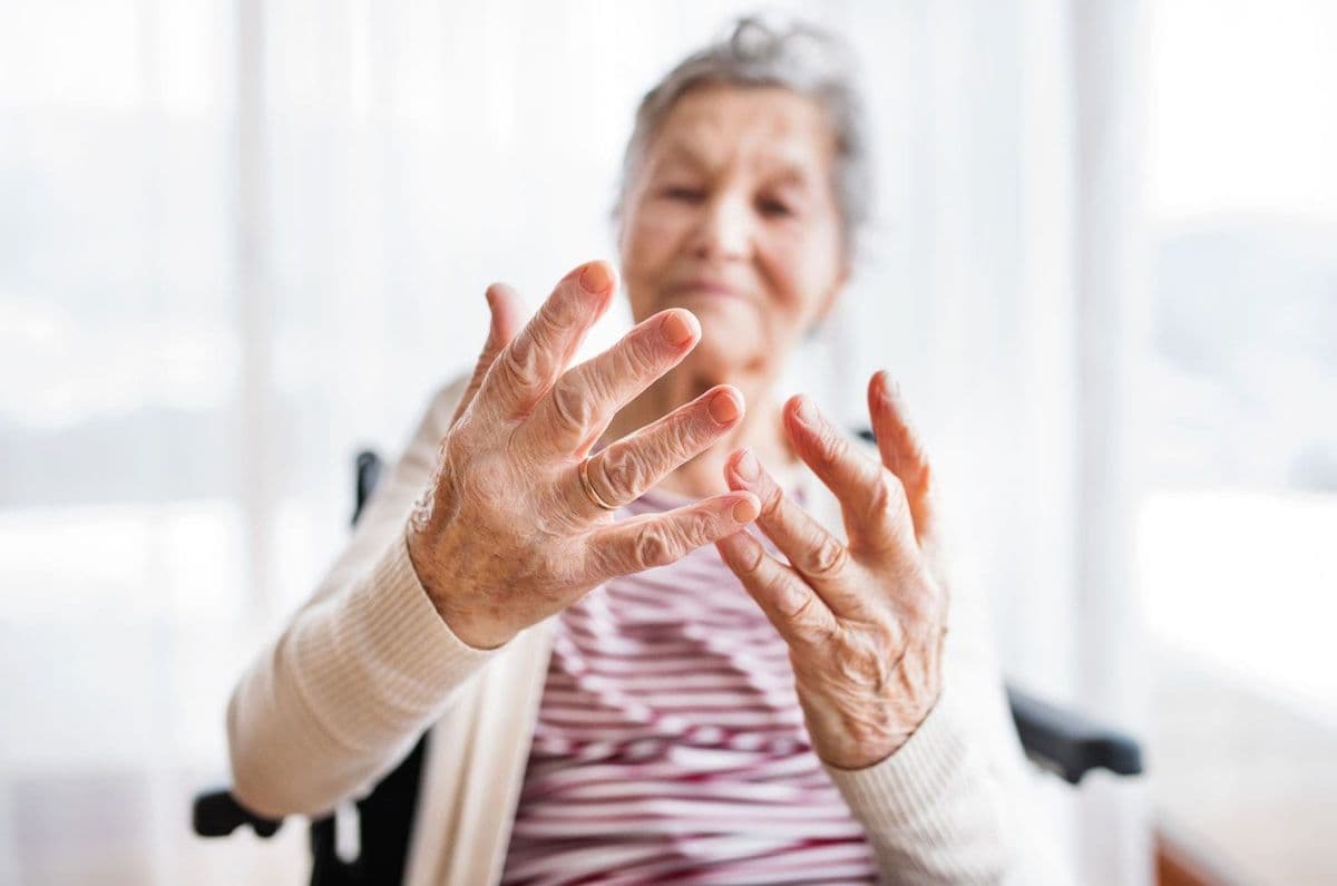 Elderly lady sat in a wheelchair exercising fingers
